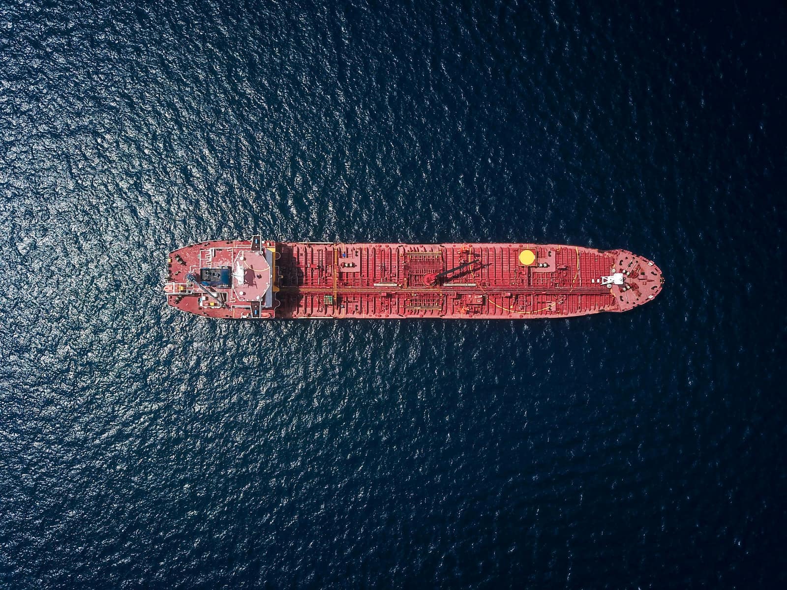 A cargo vessel underway on the open sea at sunrise